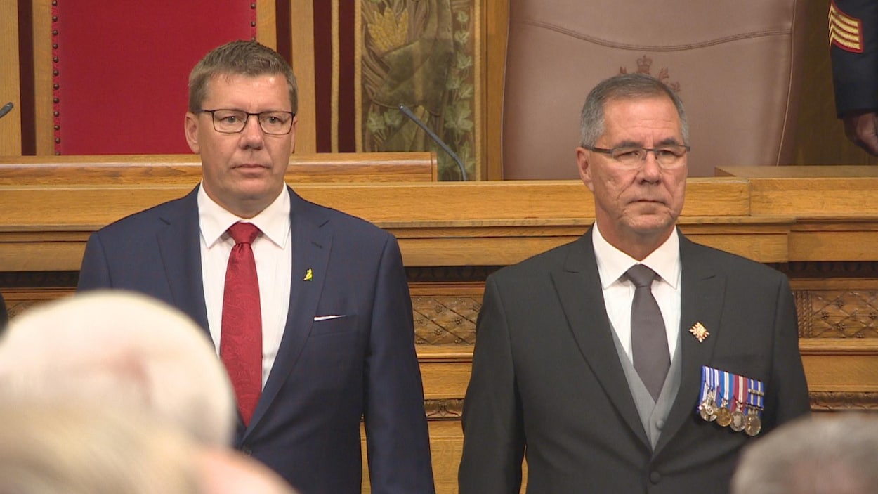 Plan moyen de Scott Moe et de Russell Mirasty debout côte à côte au palais législatif.