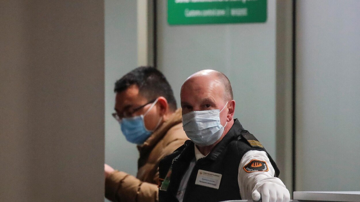 Un agent de sécurité portant un masque a l'aéroport de Moscou.