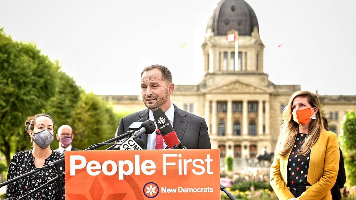 Ryan Meili répond aux questions des journalistes. Autour de lui, des candidats du NPD portant un masque.