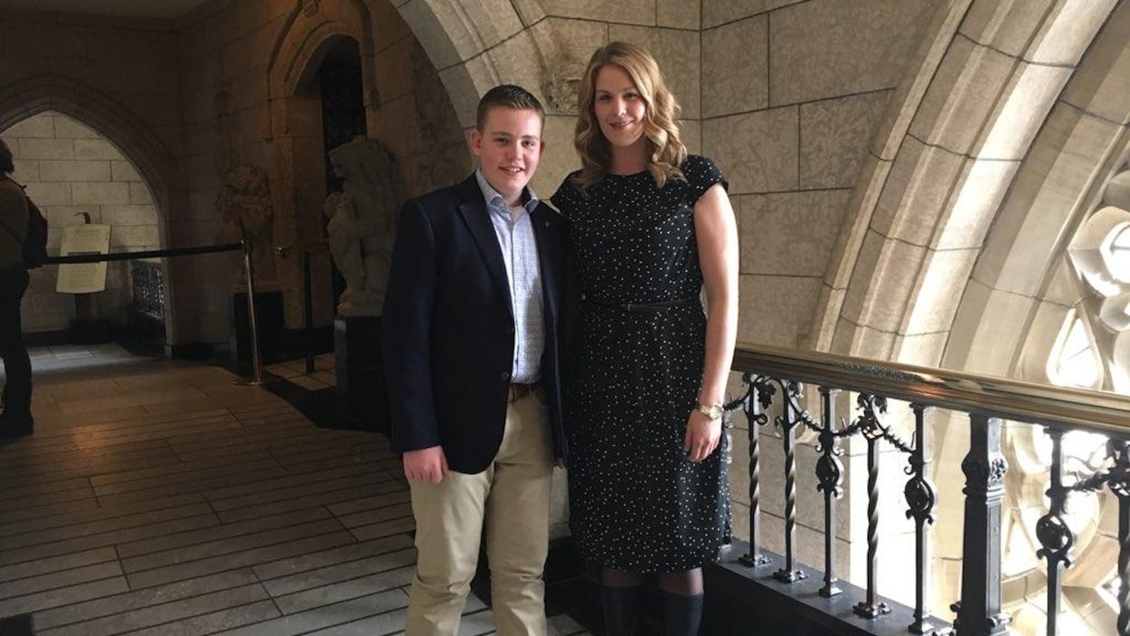 Le jeune Ryan Slingerland et sa députée, Rachael Harder, dans un corridor du parlement, à Ottawa.