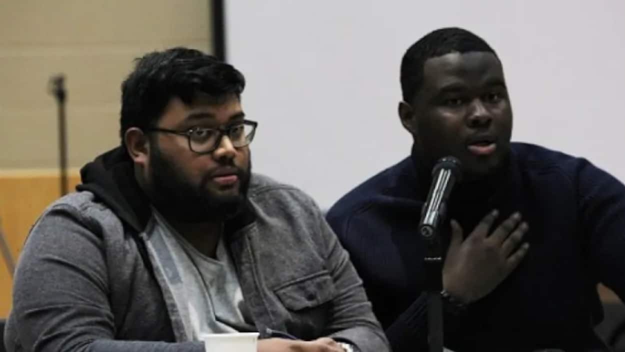 Deux jeunes hommes devant un micro.