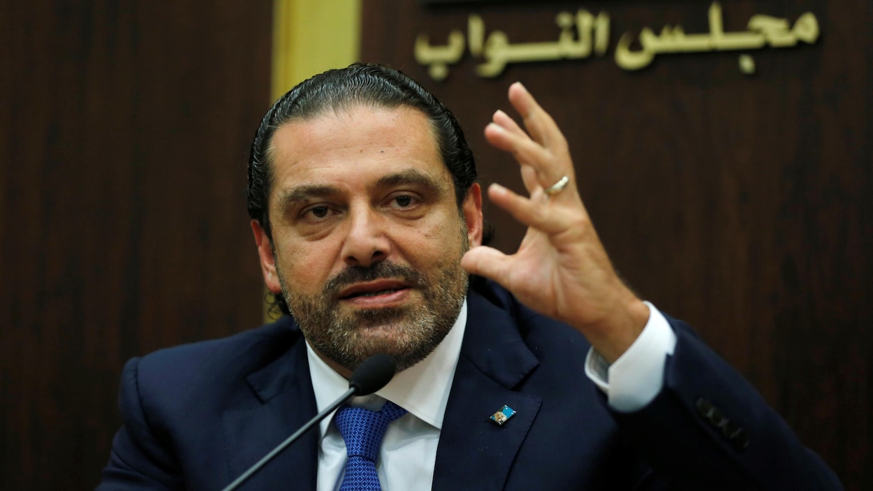 Saad Hariri, qui porte un complet bleu marine, lève la main gauche. Saad Hariri, qui porte un complet bleu marine, lève la main gauche.