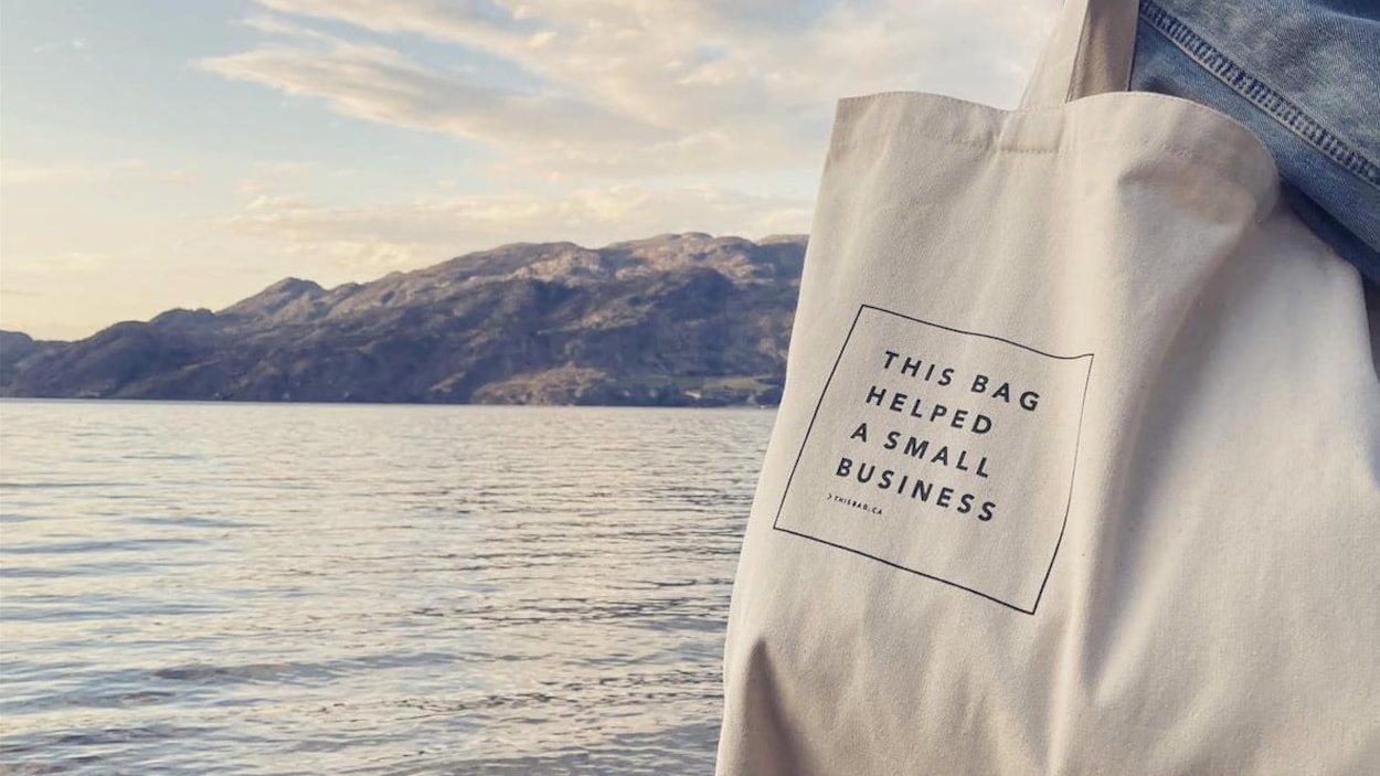 Une personne porte un sac sur lequel on peut lire en anglais : Ce sac a aidé une petite entreprise.