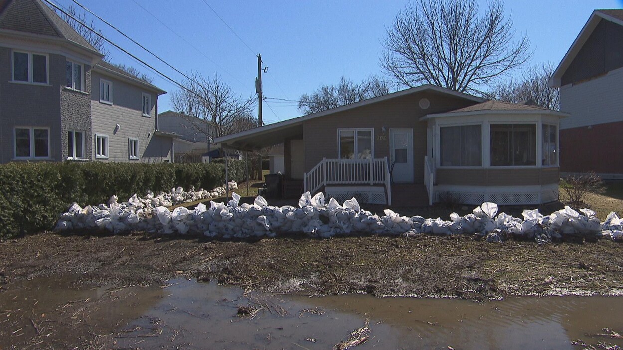 Maison à Nicolet avec des sacs de sable devant le terrain