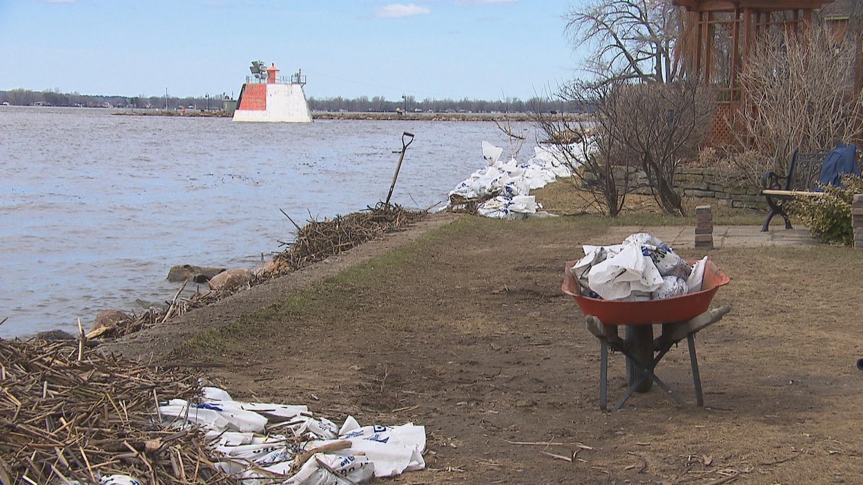 Des sacs de sables sur le bord du fleuve à Nicolet. et une brouette remplie de sacs