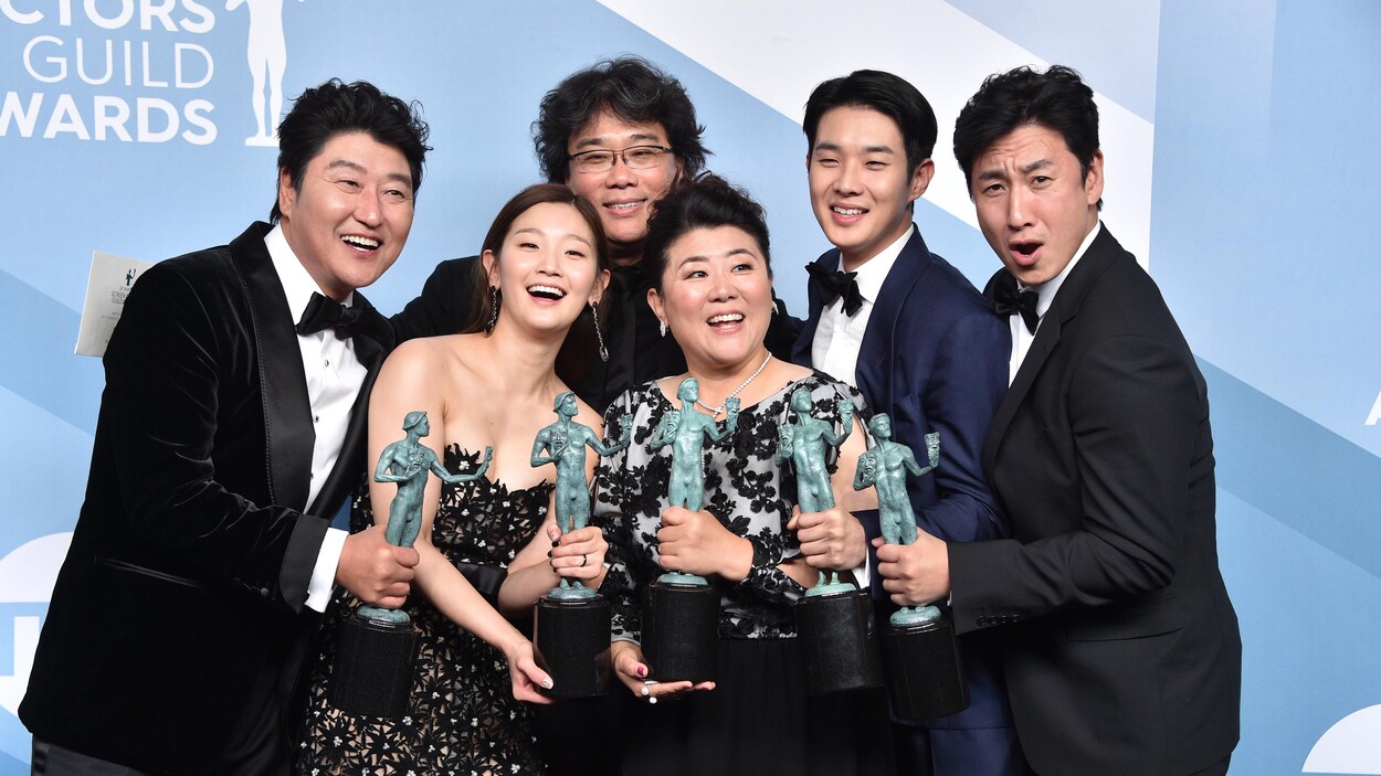 Six personnes tiennent des trophées dans leurs mains.
