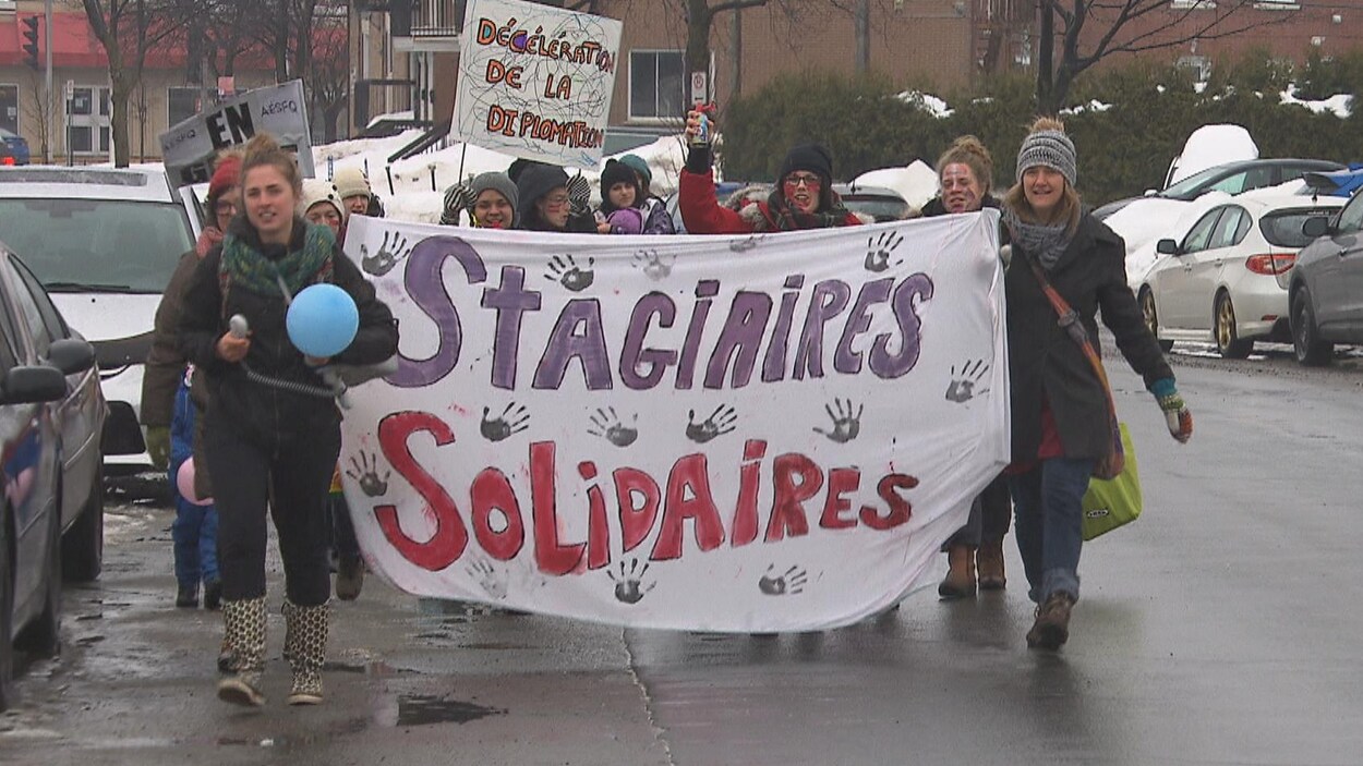 Des étudiantes tiennent une banderole où on peut lire « stagiaires solidaires ».