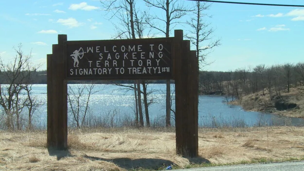 Une pancarte, placée devant un lac, marque l'entrée de la Première Nation de Sagkeeng.