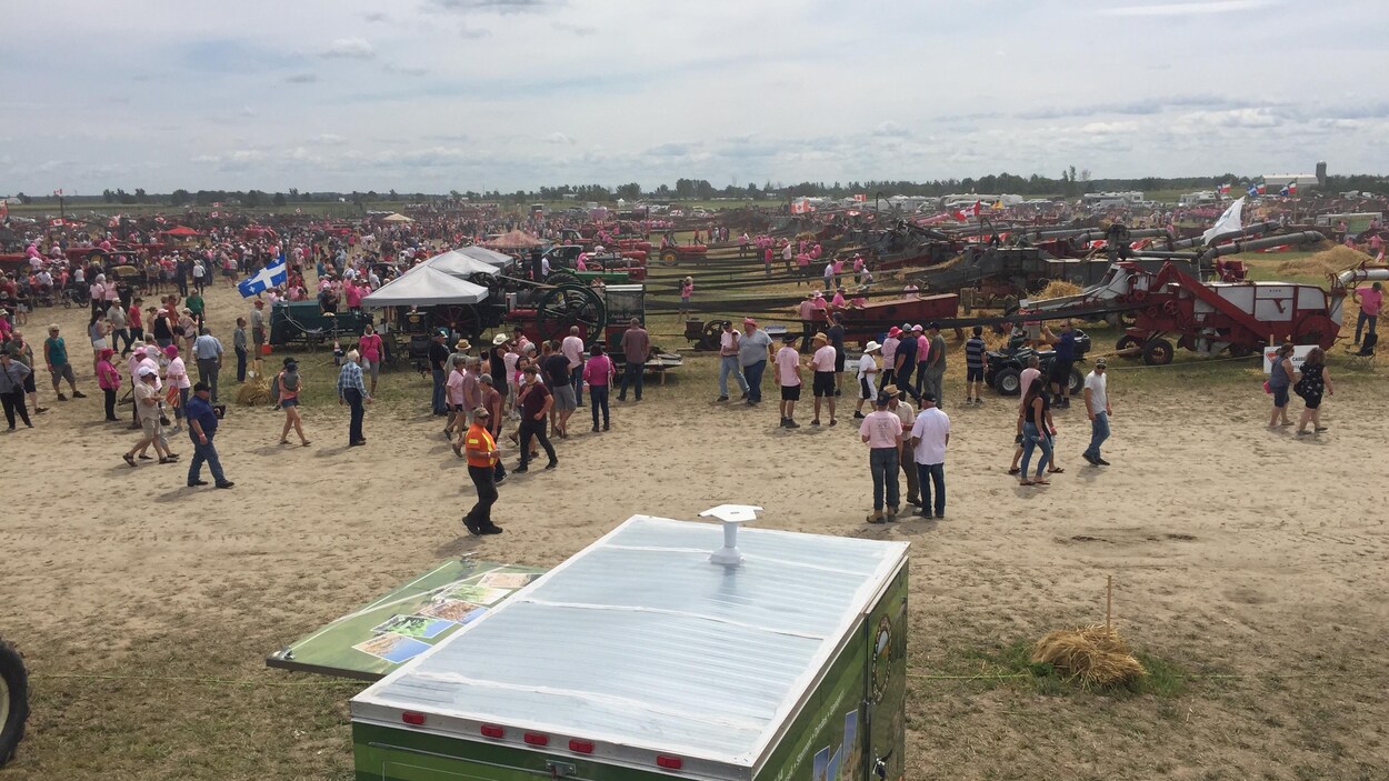 Des personnes circulent à pied entre des équipements de récolte.