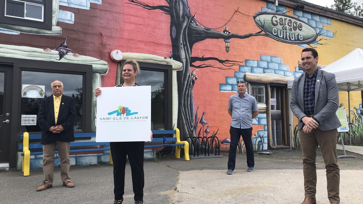 Quatre personnes se tiennent devant le Garage de la culture à Saint-Élie-de-Caxton.
