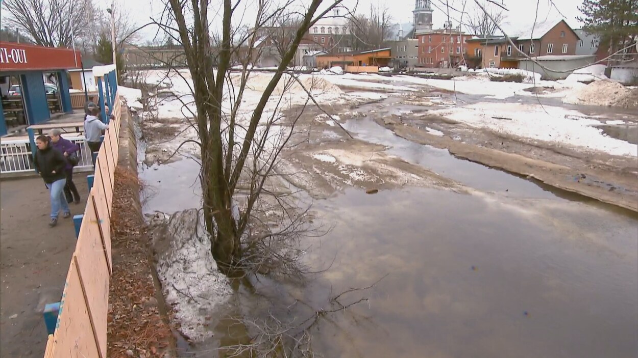 Des citoyens en bordure de la rivière Sainte-Anne, à Portneuf.