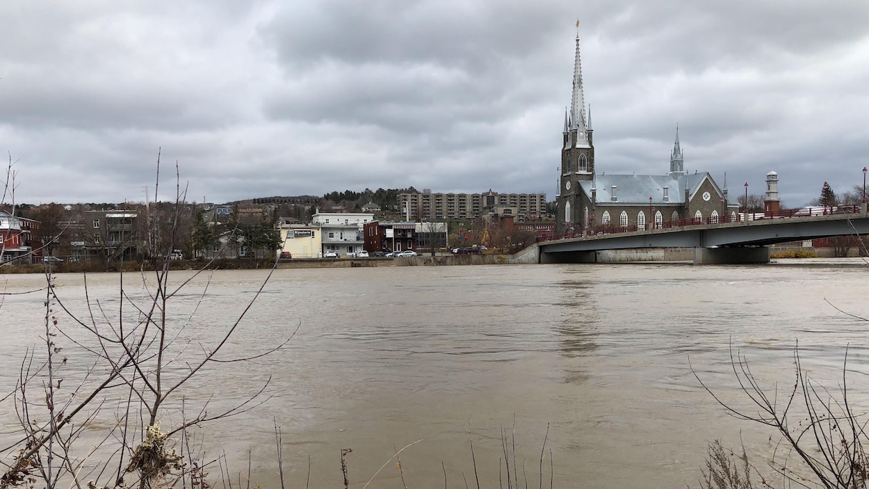Le centre-ville de Sainte-Marie apparaît sous un ciel menaçant, alors que la rivière Chaudière atteint un niveau inquiétant près de l'église situé au coeur de la municipalité.