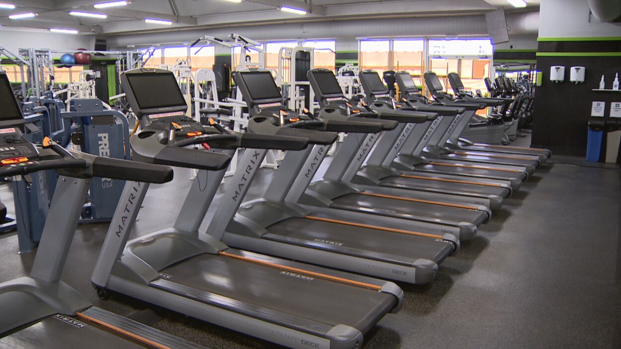Une salle de sport avec des tapis de course vident