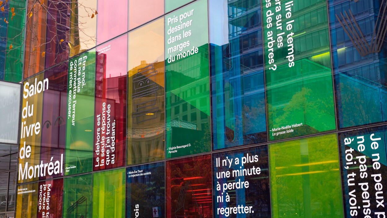 Des phrases d'autrices et d'auteurs sont affichées sur les vitres de différentes couleurs Palais des congrès.