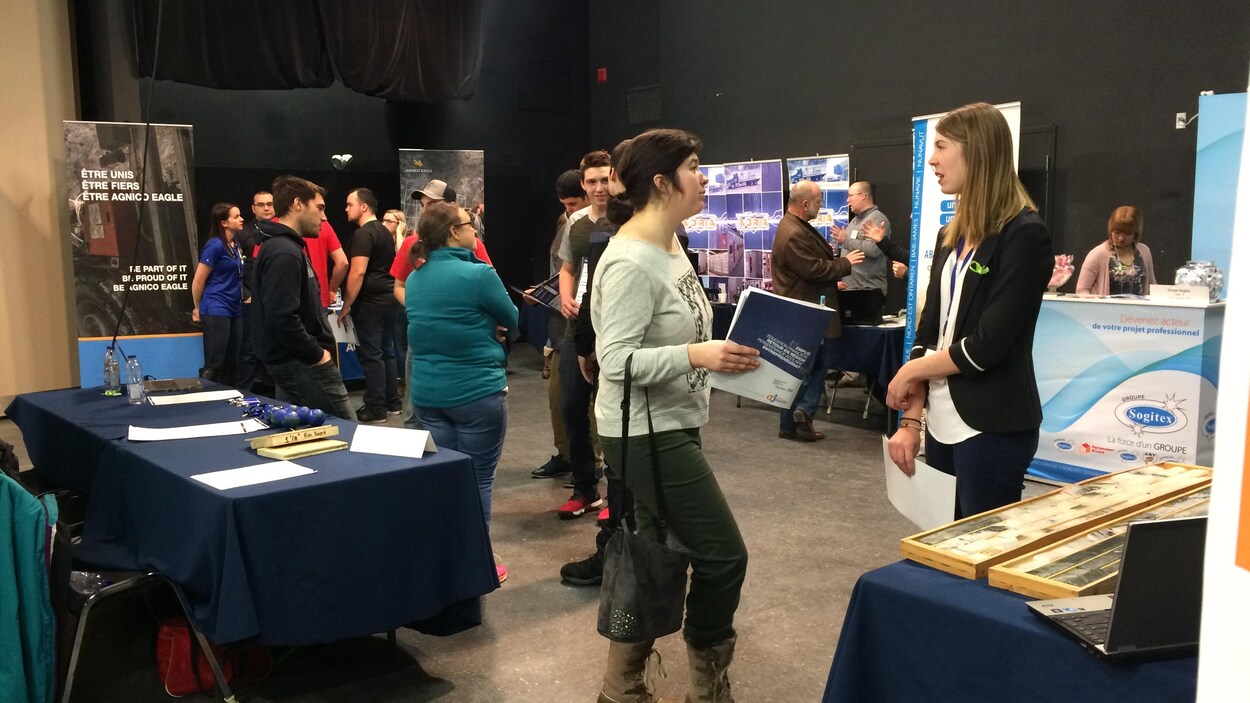 Des gens discutent dans le cadre d'un salon d'exposants. Des gens discutent dans le cadre d'un salon d'exposants.