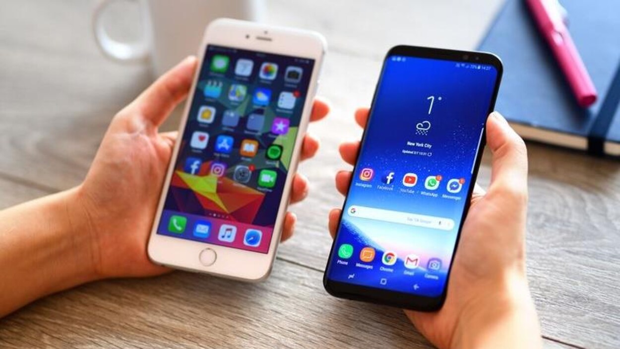 Une personne tient un iPhone 6 Plus à côté d'un Samsung Galaxy S9 Plus.