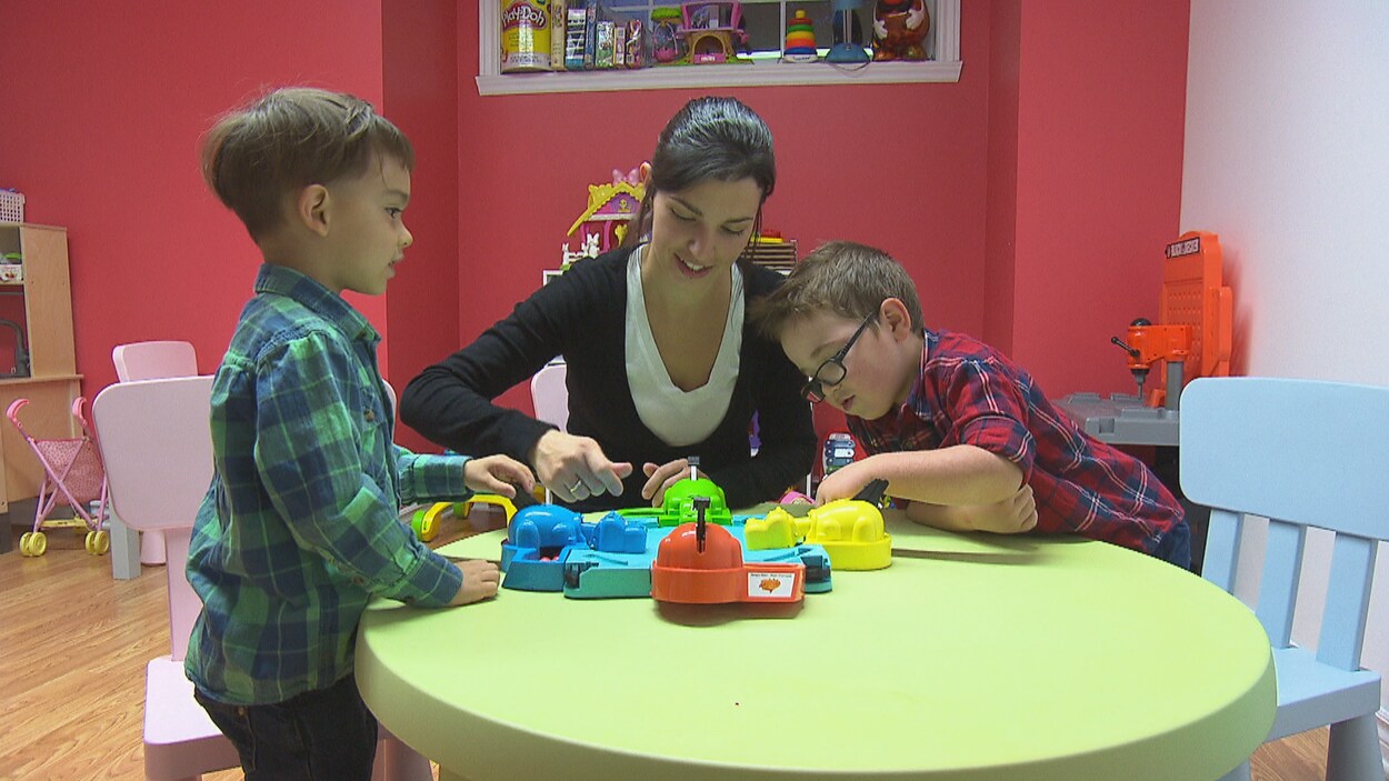 Une éducatrice avec deux enfants dans une garderie.