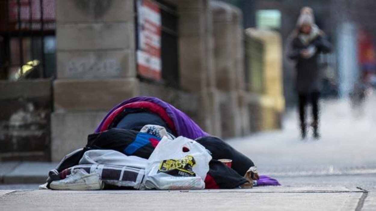 Un sans-abri dort sur le trottoir. Un sans-abri dort sur le trottoir.