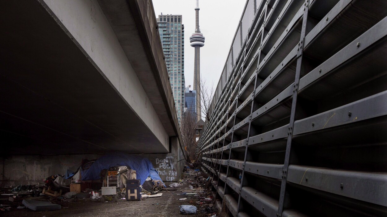 Un camp de sans-abri sous une rampe d'accès à Toronto.