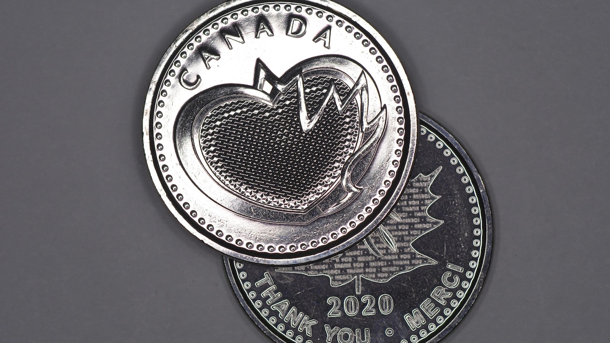 Une médaille en acier sur lequel on voit un coeur et la feuille d’érable.