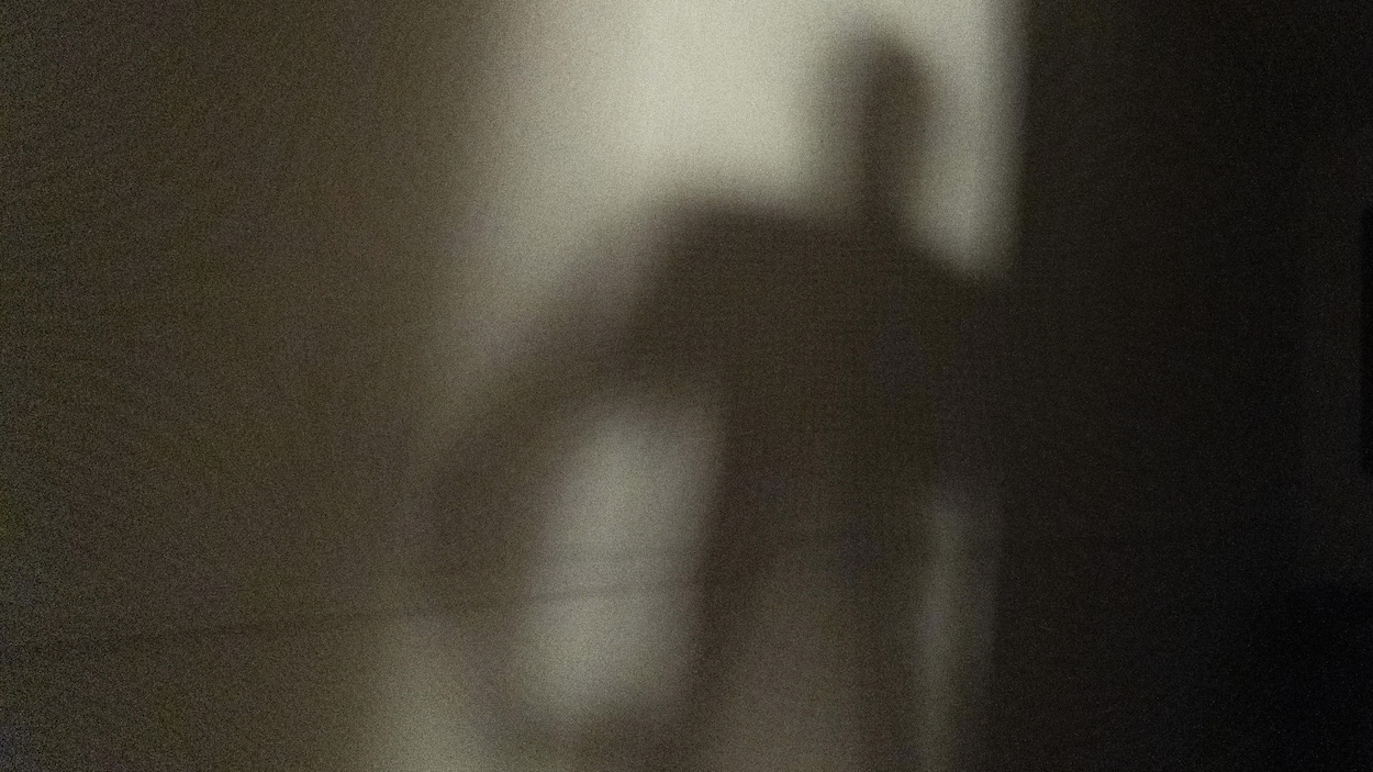 La silhouette d'un homme se dessine dans le cadre d'une porte