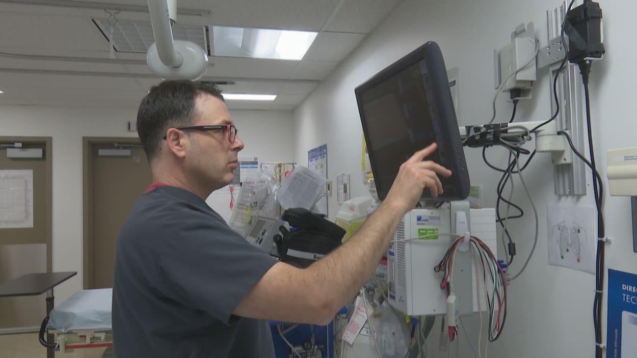 Un infirmier travaille avec un écran tactile dans une clinique.