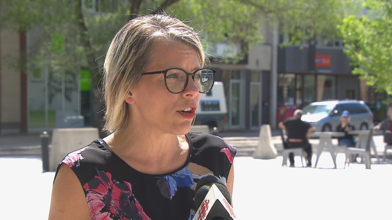 Une femme parle dans un micro au centre-ville.