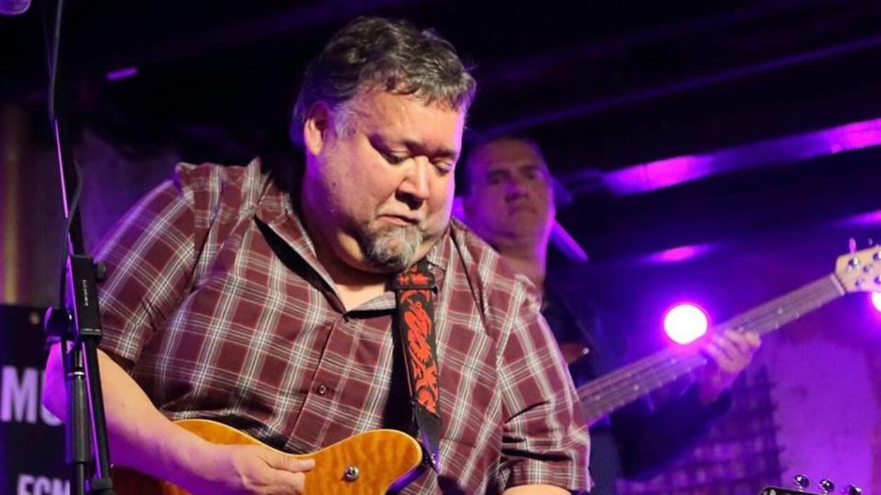 Gary Sappier joue de la guitare sur scène