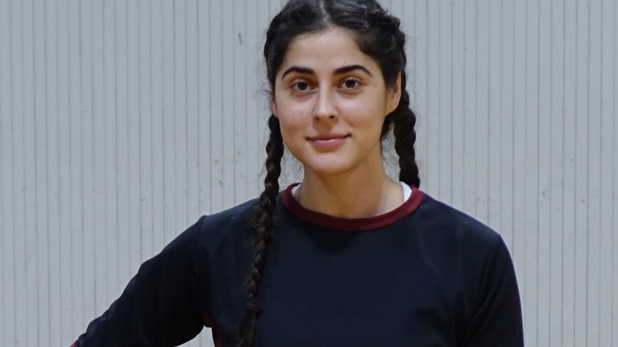 Sarah Abood tient un ballon de basket dans ses mains. Sarah Abood tient un ballon de basket dans ses mains.