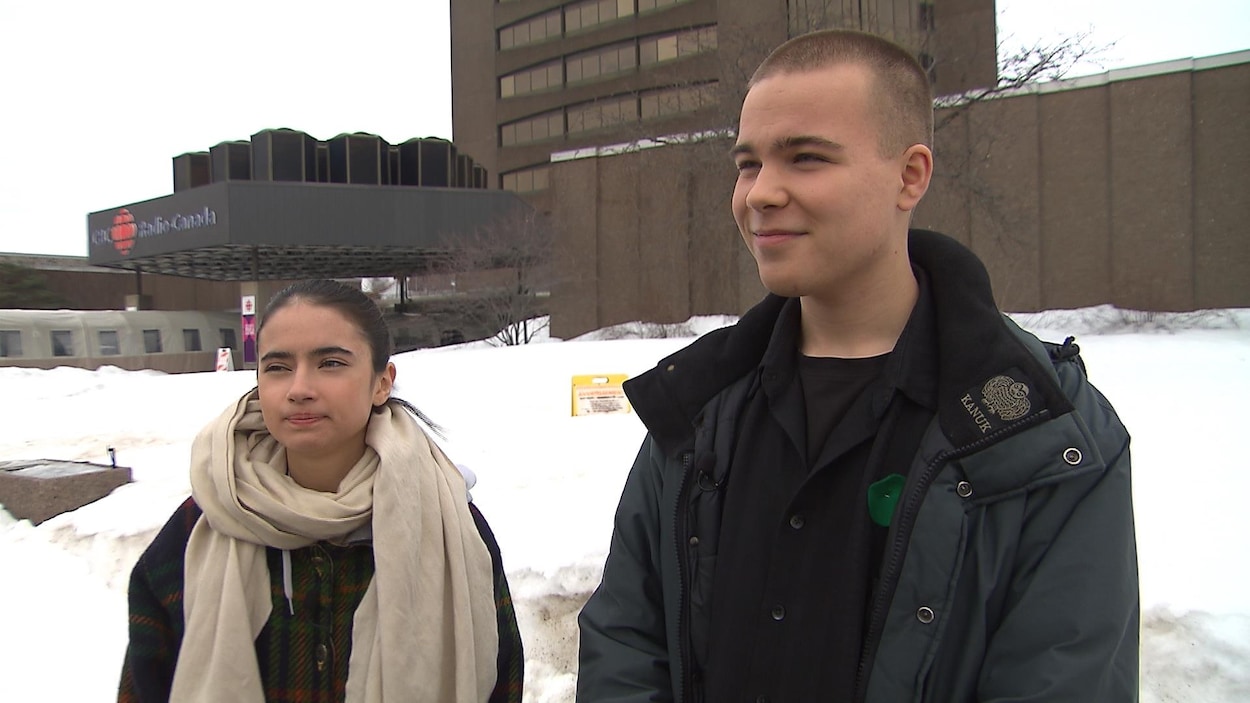 Un adolescent et une adolescente dehors.