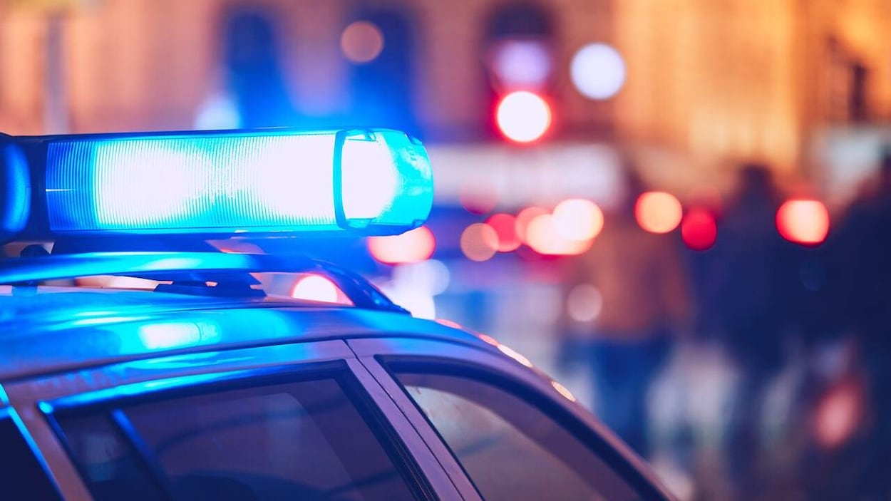 Une voiture de police avec gyrophare allumé.