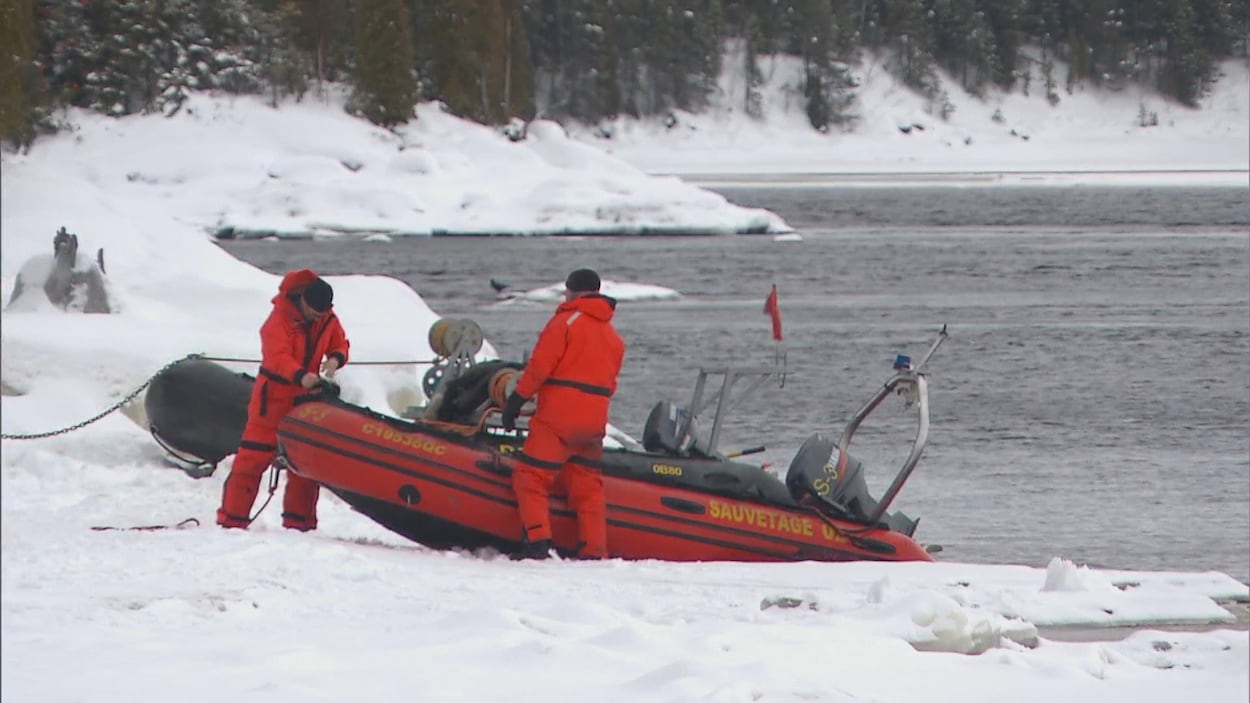 Deux secouristes et un bateau pneumatique.