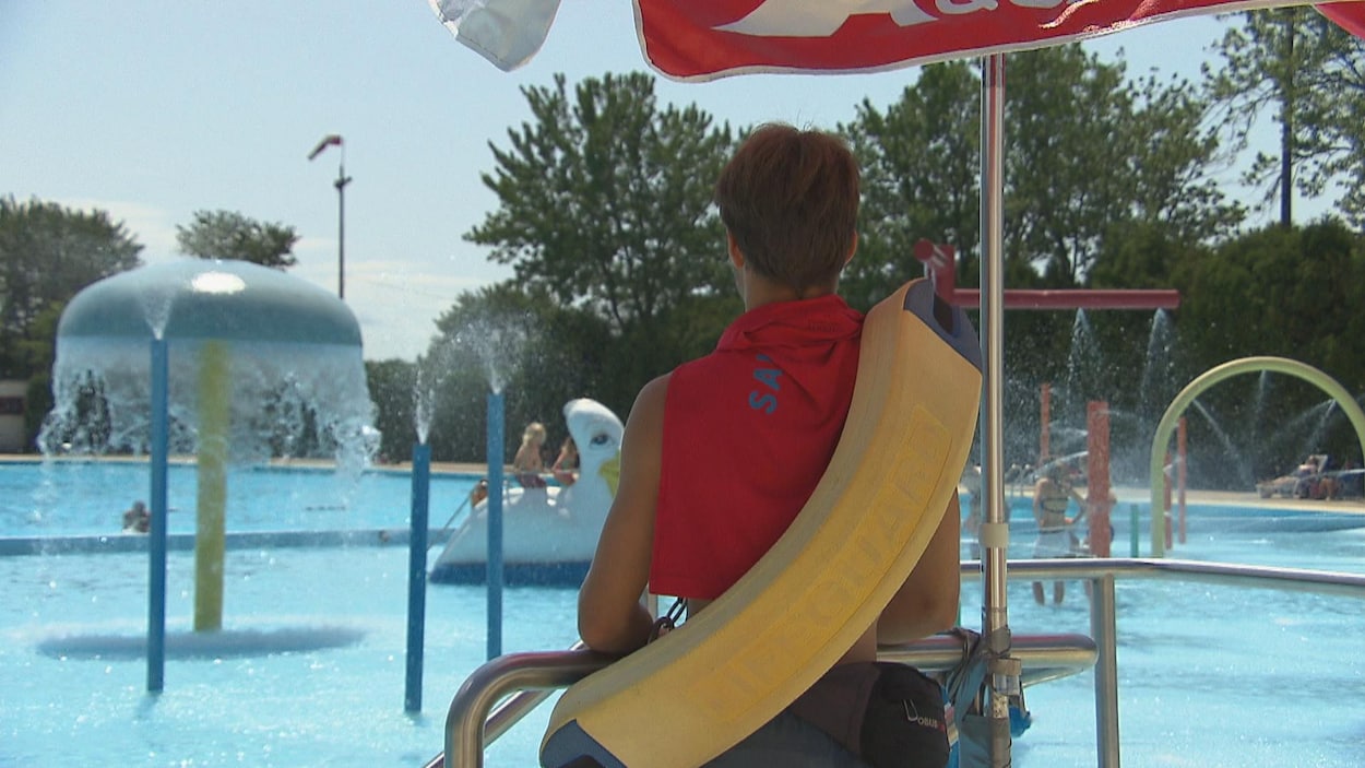 Sauveteur sur une chaise qui regarde des enfants.