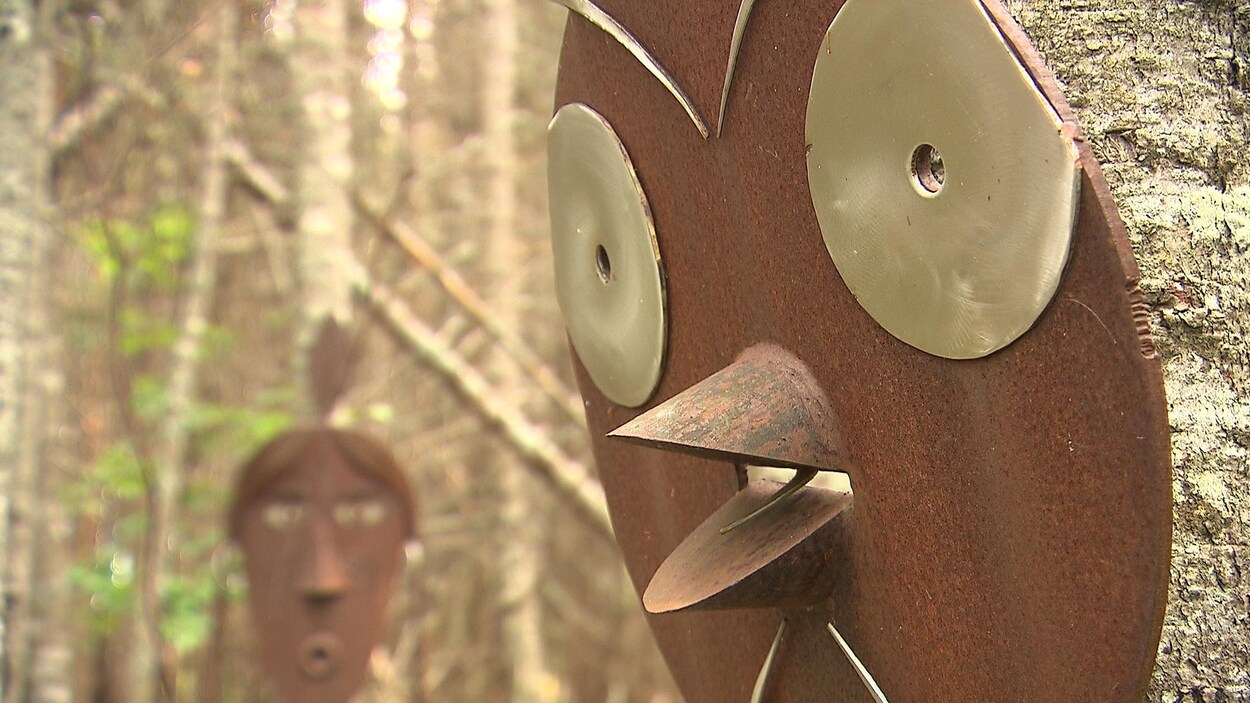 Une sculpture d'oiseau en fer dans une forêt