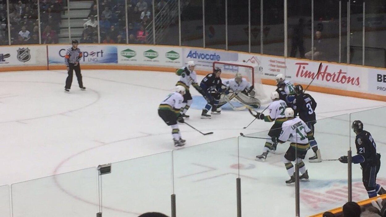 Une mêlée de hockeyeurs devant le filet