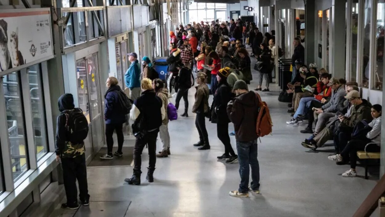 Des passagers dans une salle d'attente du services du SeaBus.