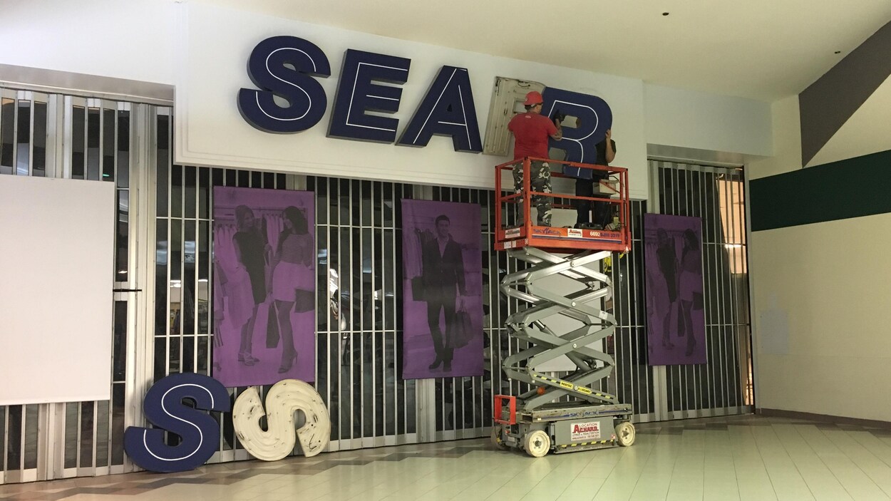 Des ouvriers retirent les lettres du mot Sears. Des ouvriers retirent les lettres du mot Sears.