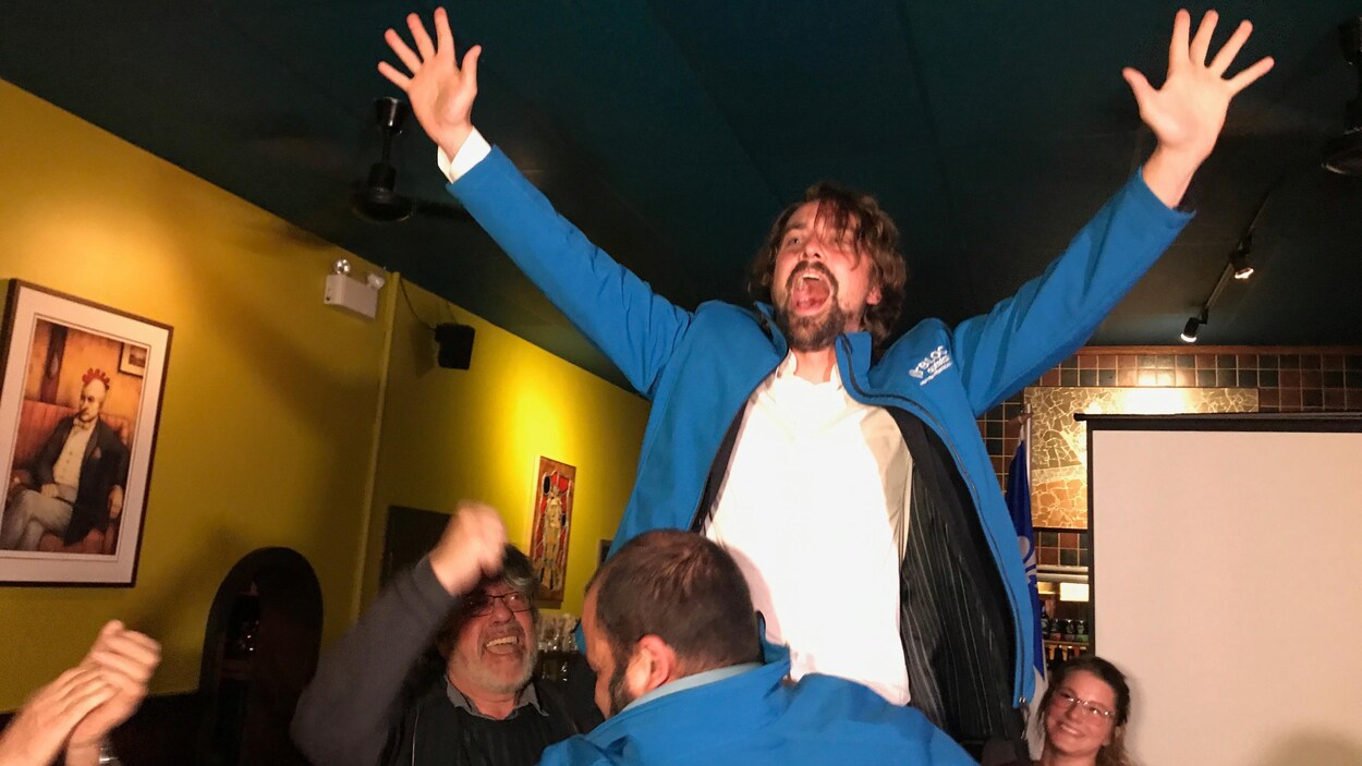 Sébastien Lemire crie, les bras en l'air, soulevé par un partisan.