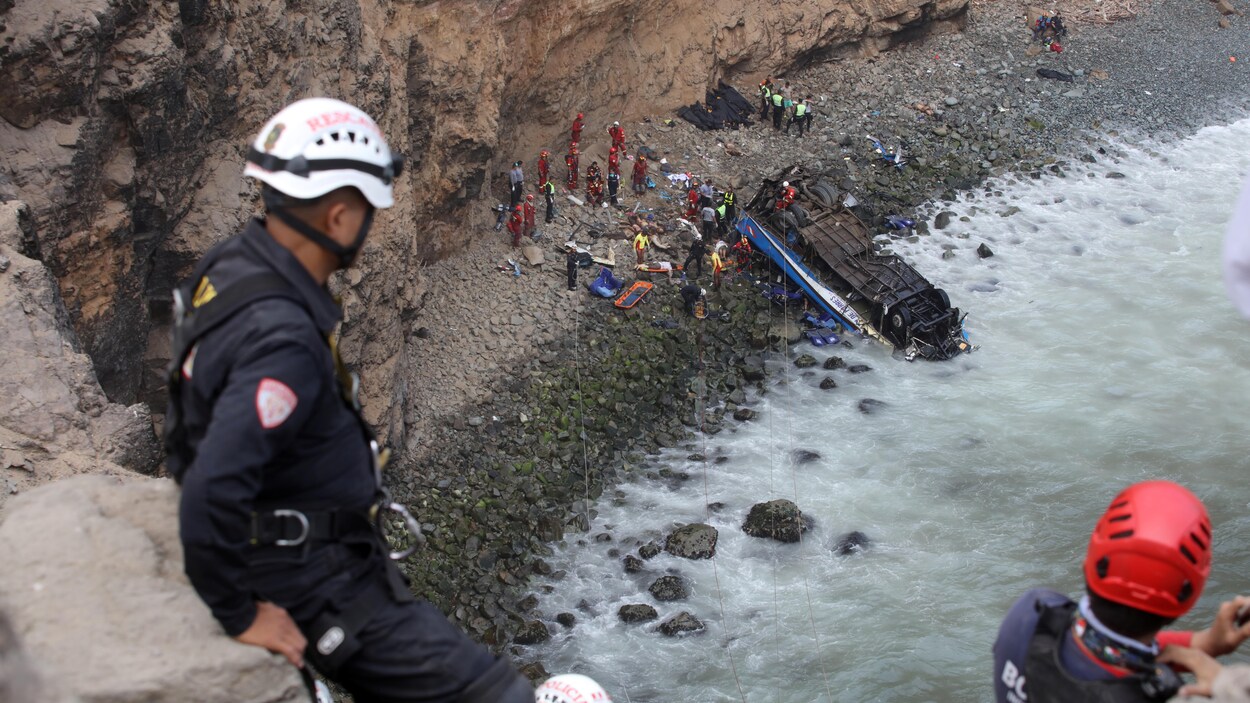 Des secouristes observent au loin l'autocar qui s'est écrasé à l'envers sur une plage au Pérou. Des secouristes observent au loin l'autocar qui s'est écrasé à l'envers sur une plage au Pérou.