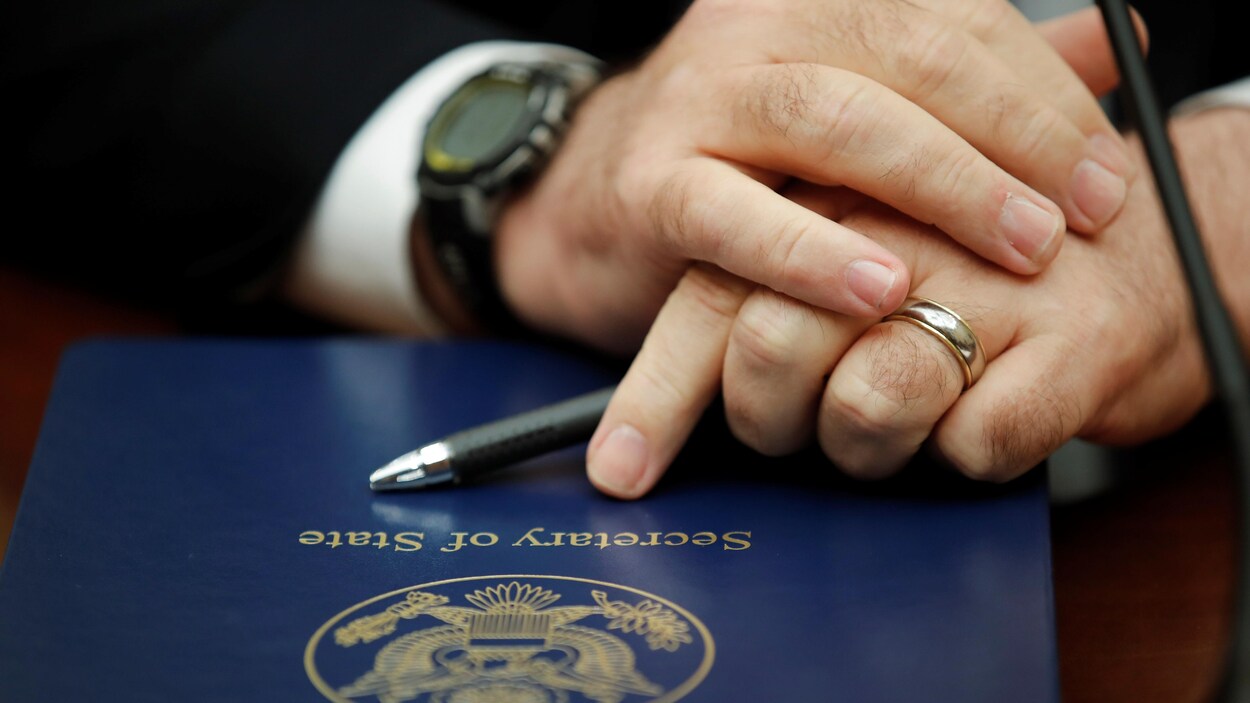 Les mains d'un homme croisées sur un dossier sur lequel il est écrit Secretary of State.