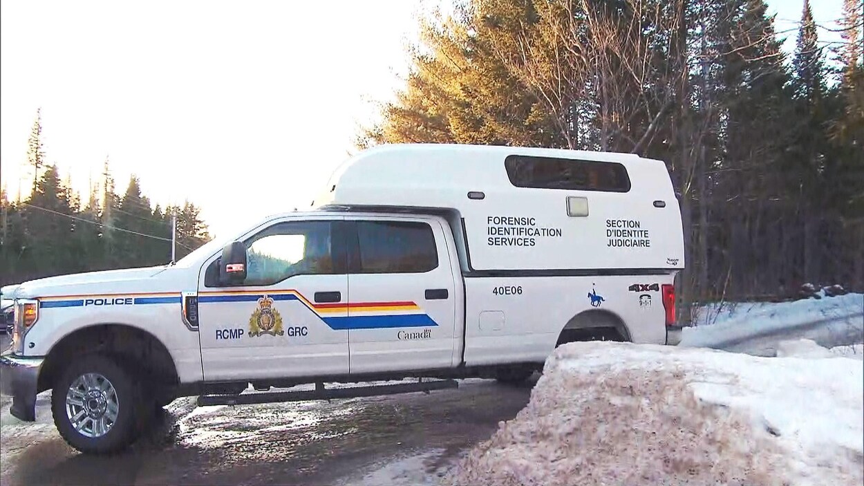 Véhicule de la section d'identité judiciaire de la Gendarmerie royale du Canada sortant d'un chemin de campagne.