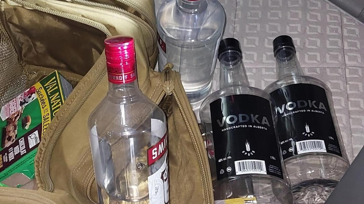 Un chauffeur de camion arrêté avec des bouteilles de vodka ouvertes en cabine