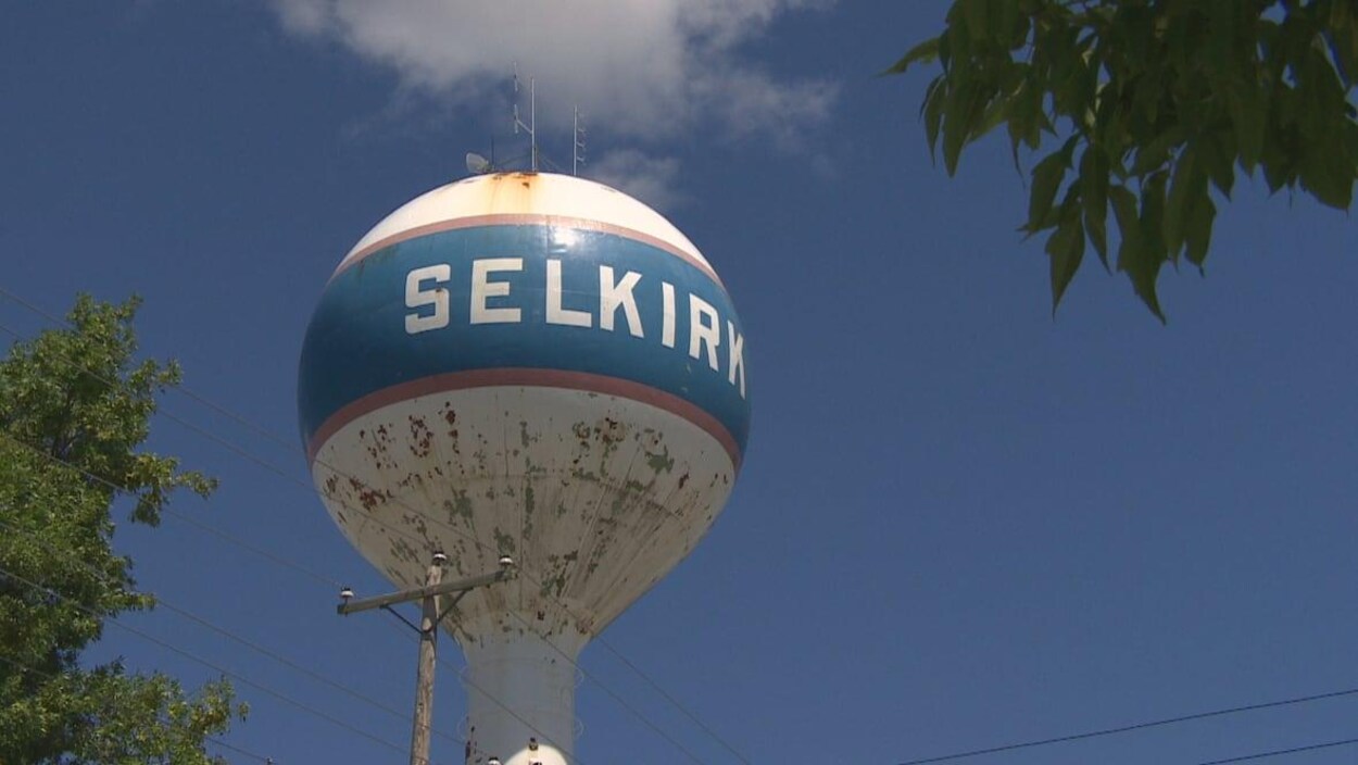 Un réservoir en forme de boule planté sur une colonne s'élève dans le vaste ciel du Manitoba.