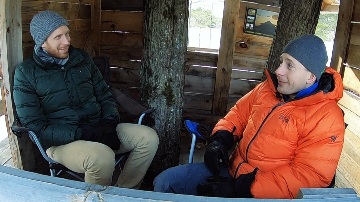 Les deux hommes assis dans une cabane en bois