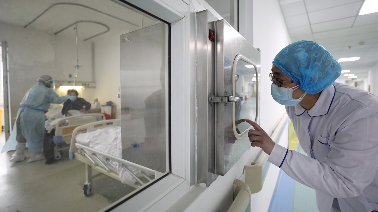 Des travailleurs de la santé et un patient dans un secteur isolé d'un hôpital.