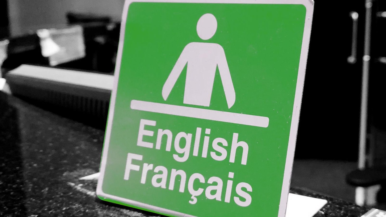 Une affiche sur laquelle on peut lire ''English'' et ''Français'' avec une icône représentant un homme derrière un bureau.