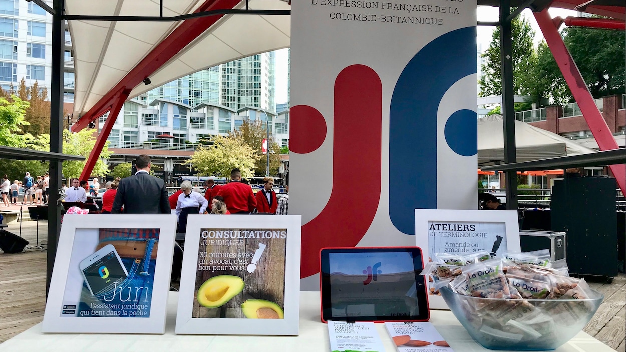 Un kiosque de l'Association des juristes d'expression française avec des dépliants, un ipad et une grande affiche.