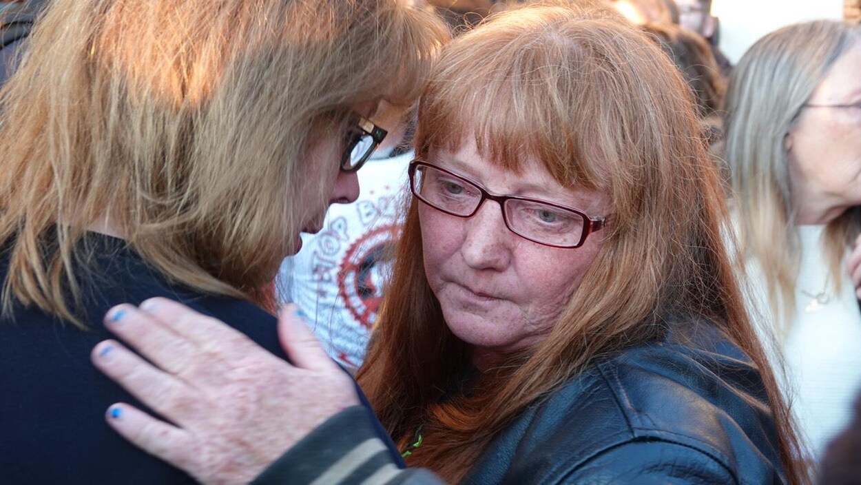 Une femme en pleurs est consolée par une proche.