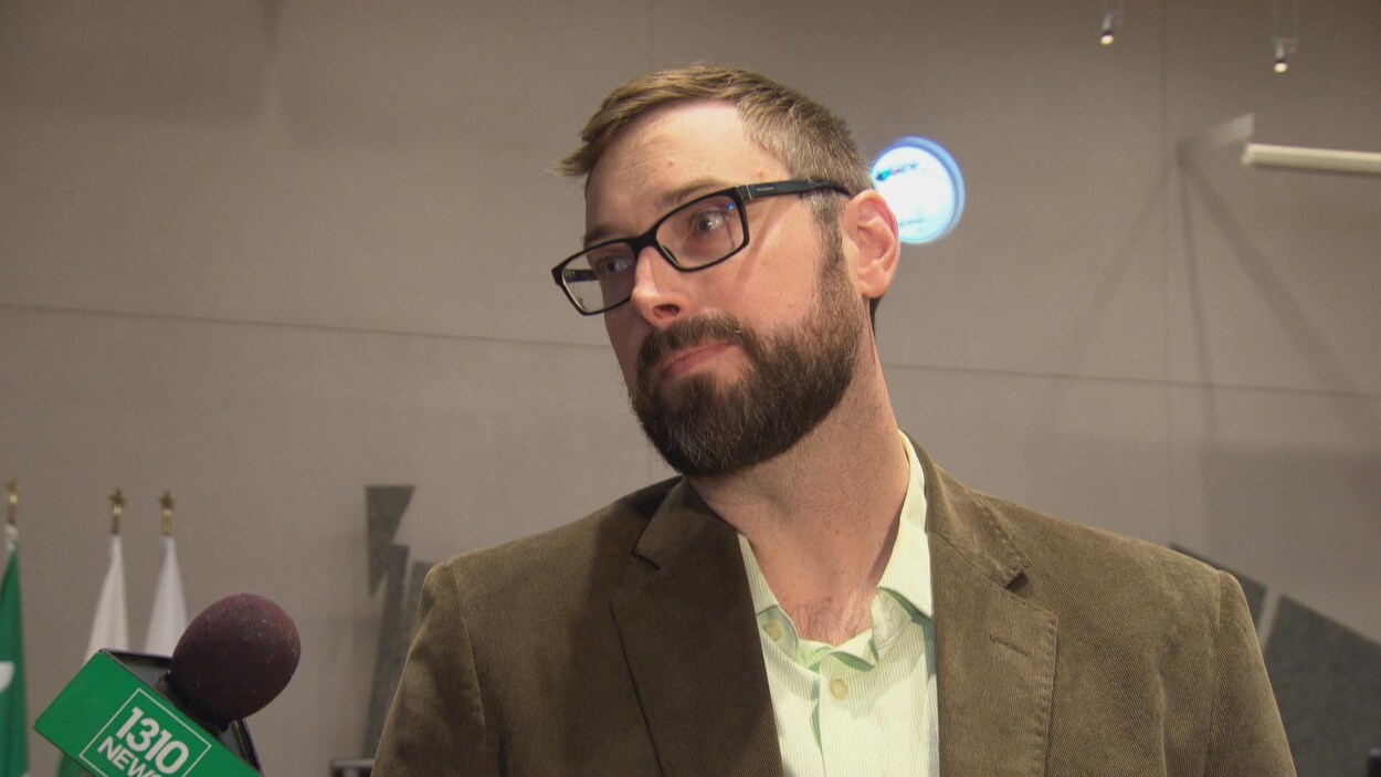 Shawn Menard dans la salle du conseil municipal d'Ottawa. À sa gauche, un micro.
