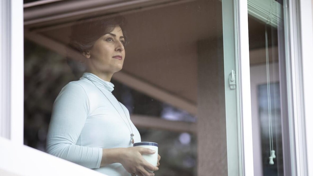 Shilan Garousi regarde par la fenêtre, un café à la main.